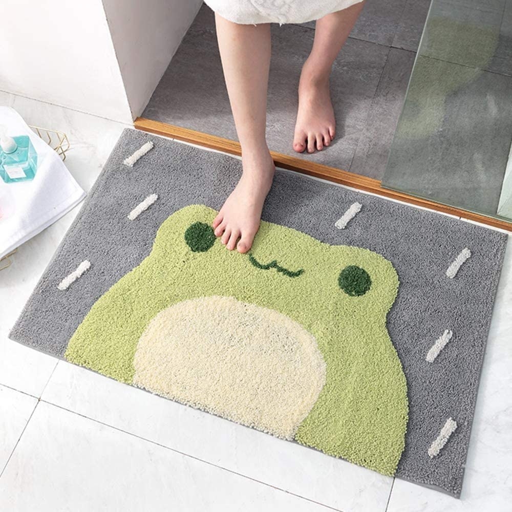 a person stepping out of the shower onto their bathroom mat