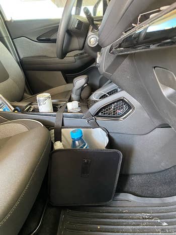 reviewer's small black trash can hanging off the gear shift into the passenger side