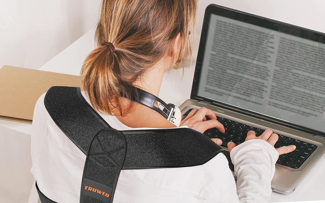 model using laptop while wearing the back brace