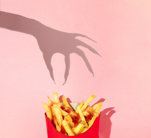 A shadow hand reaching for French fries