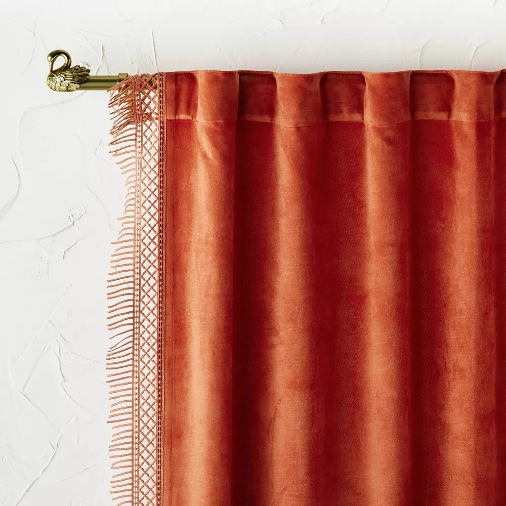 The burnt orange velvet curtain covering a window