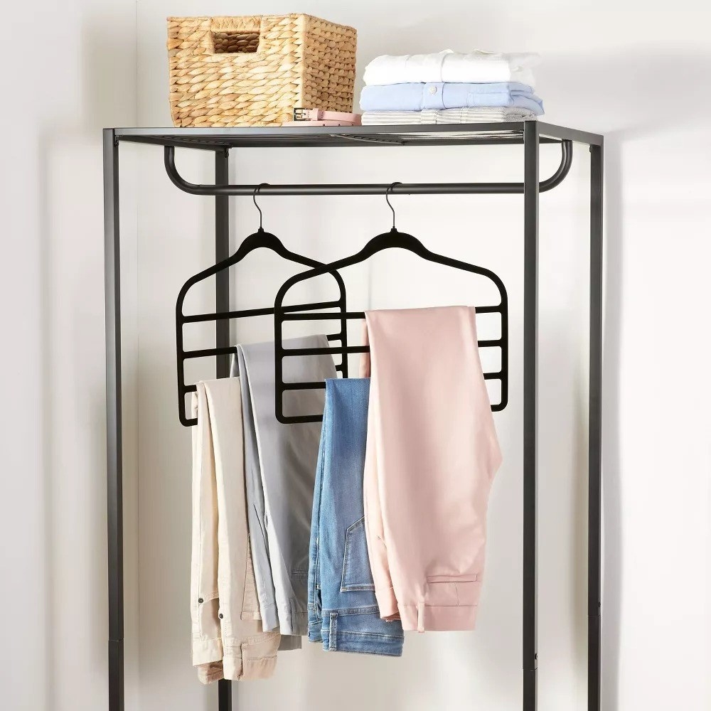 The set of two hangers with four bars and multiple pairs of pants on each one