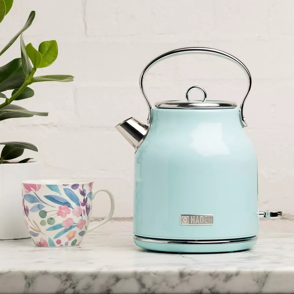 The blue tea kettle with a round handle and small spout on a kitchen counter