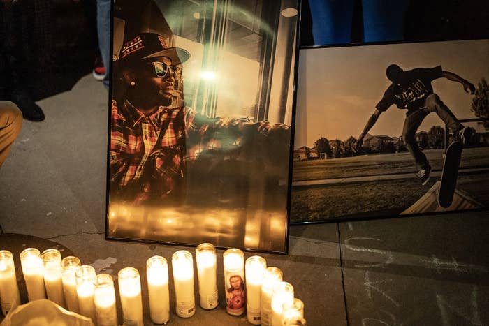 a memorial with candles and photos of Tyre Nichols at night