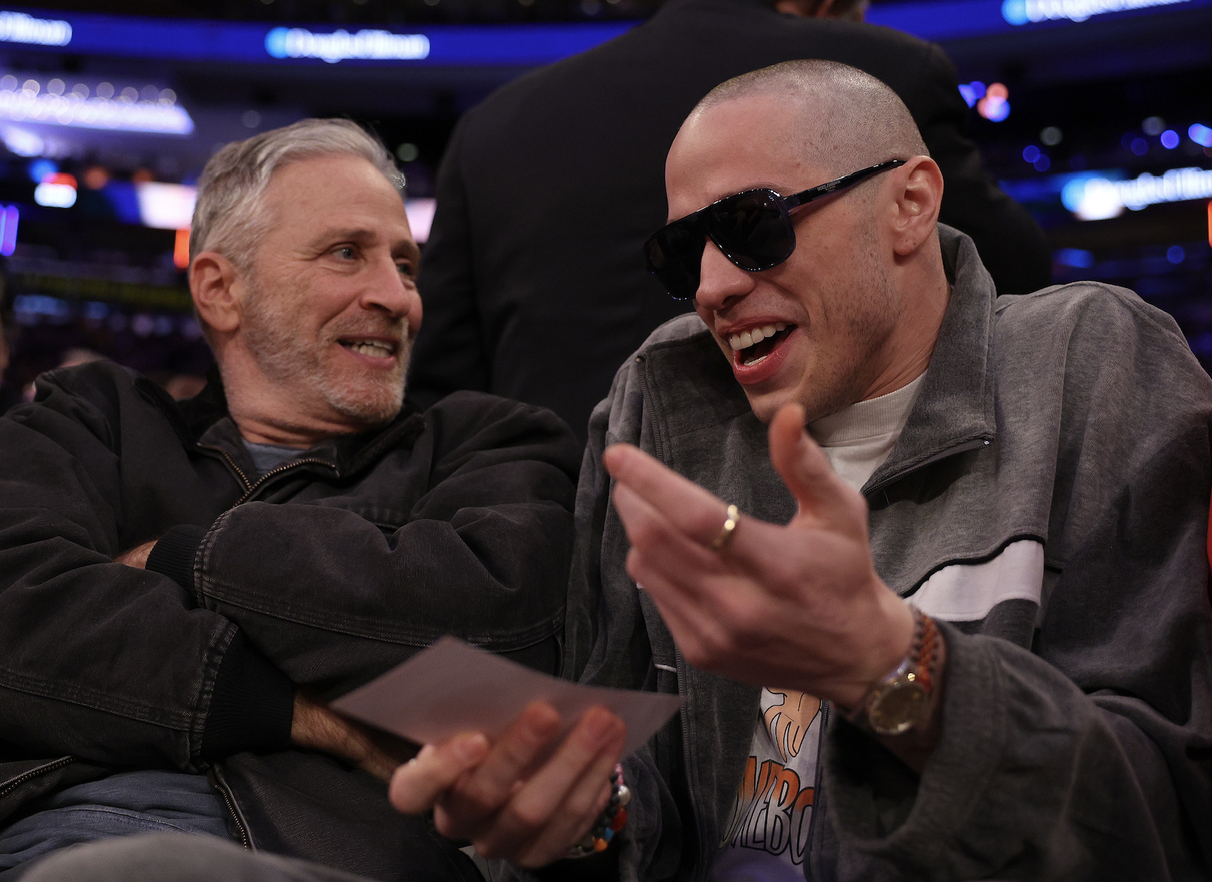 Pete, with a shaved head, sitting next to Jon Stewart and animatedly talking