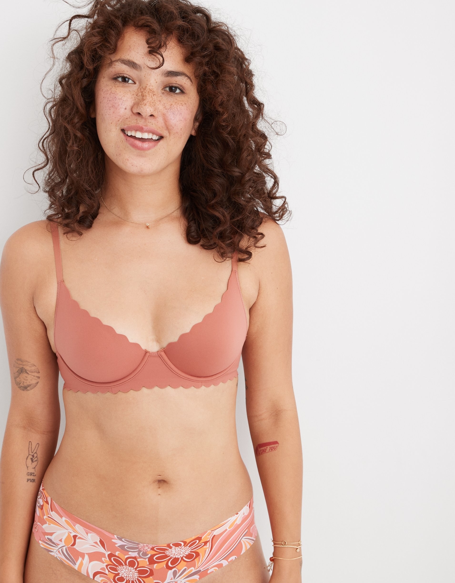 model in salmon underwire unlined bra with scalloped edges