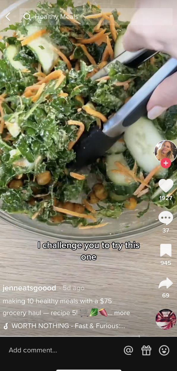 a salad in a bowl being tossed with tongs