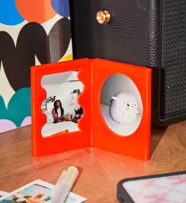 a small picture frame with two instax mini photos displayed in it