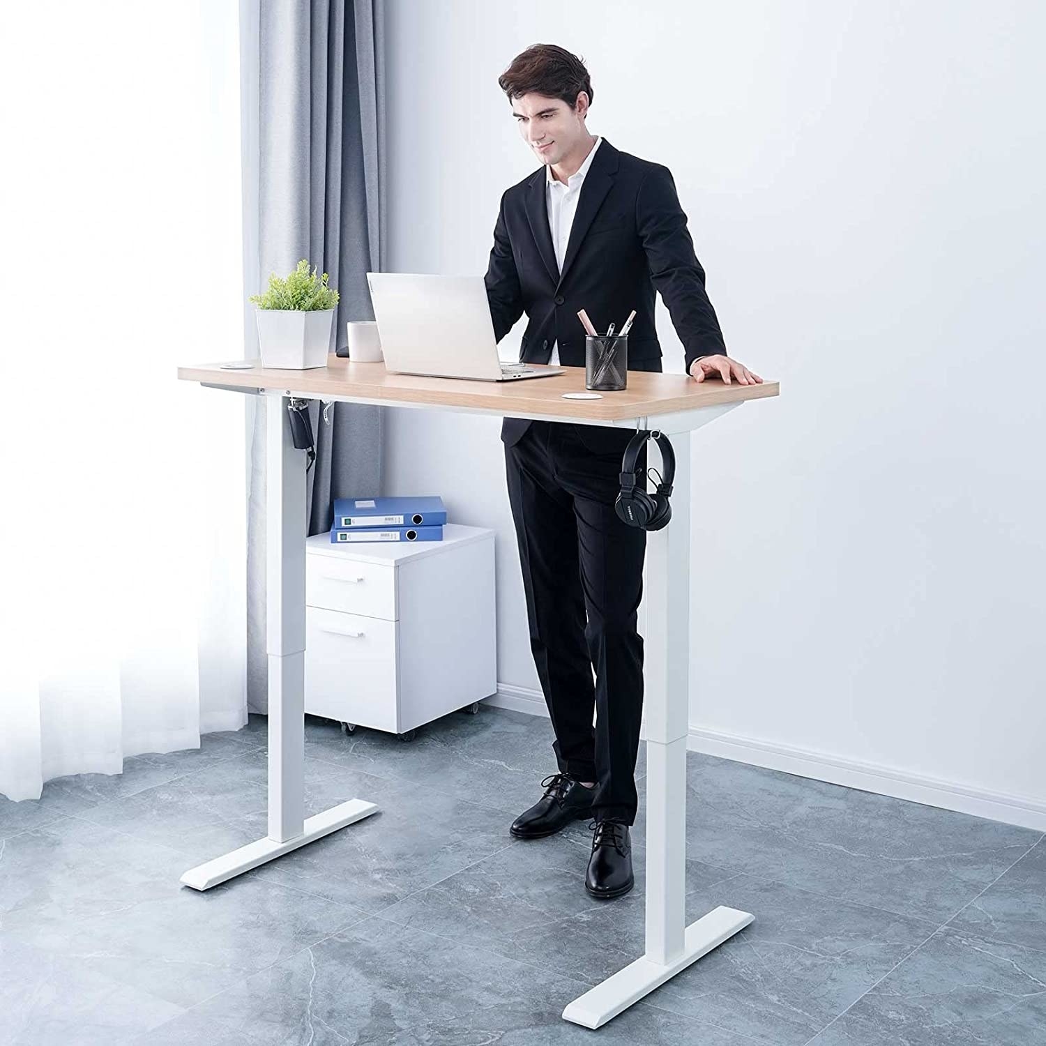 a person standing at the raised standing desk