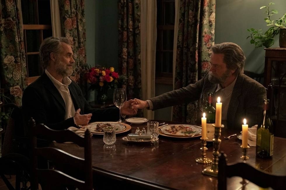 Bill and Frank hold hands across a candlelit dinner table