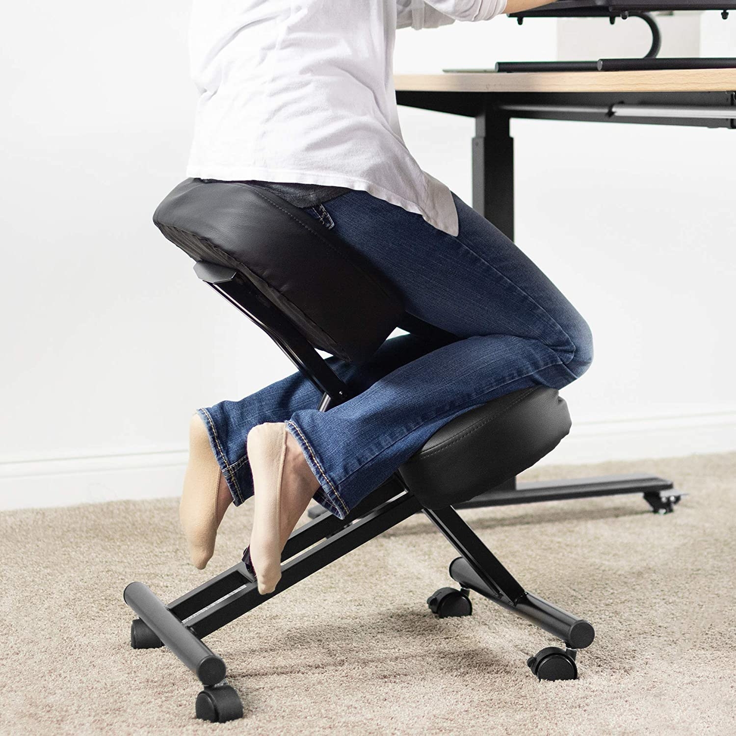 a person kneeling on an ergonomic office chair