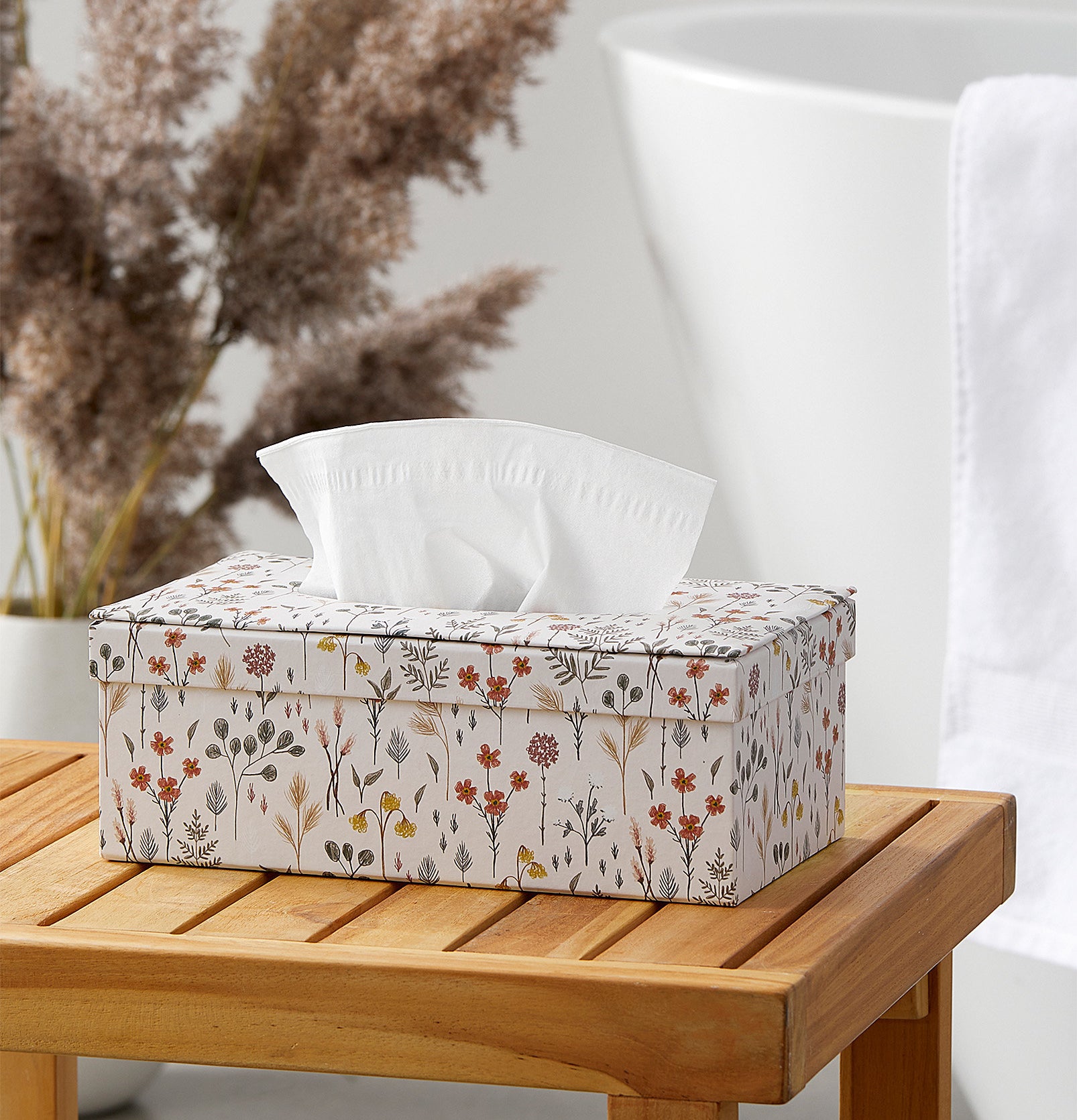 a floral tissue box holder on a wood surface