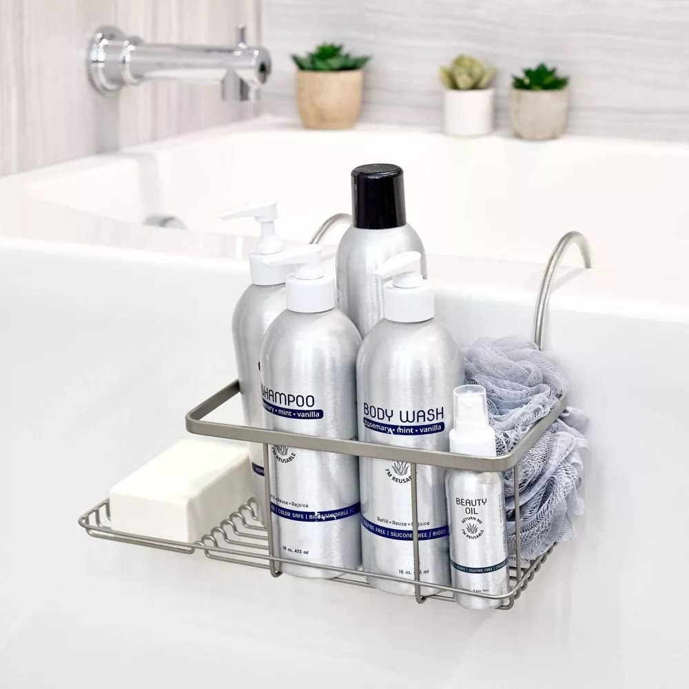 Silver ove-the-bath caddy holding bath products and bar of soap