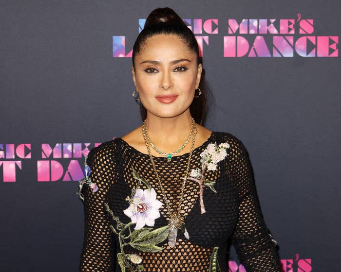 A close-up of Salma in a fishnet floral top and hair pulled back