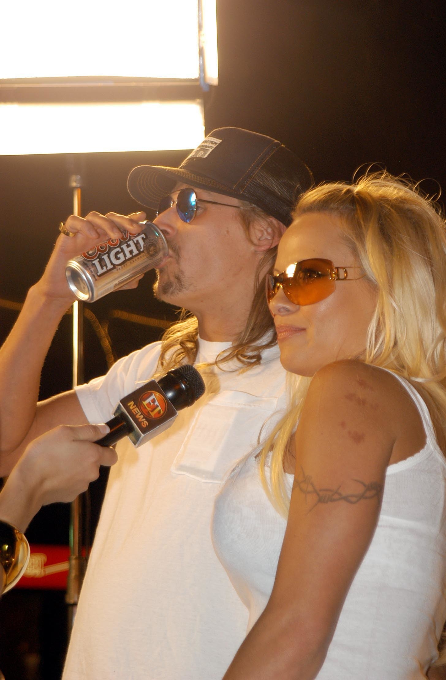 Bob drinking a can of Coors Light beer as he and Pam are being interviewed by ET News on the red carpet