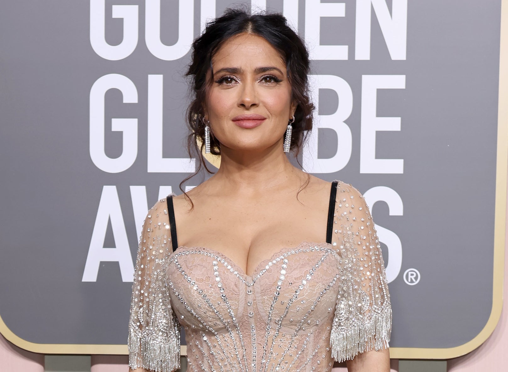 A close-up of Salma in a sparkly, low-cut outfit