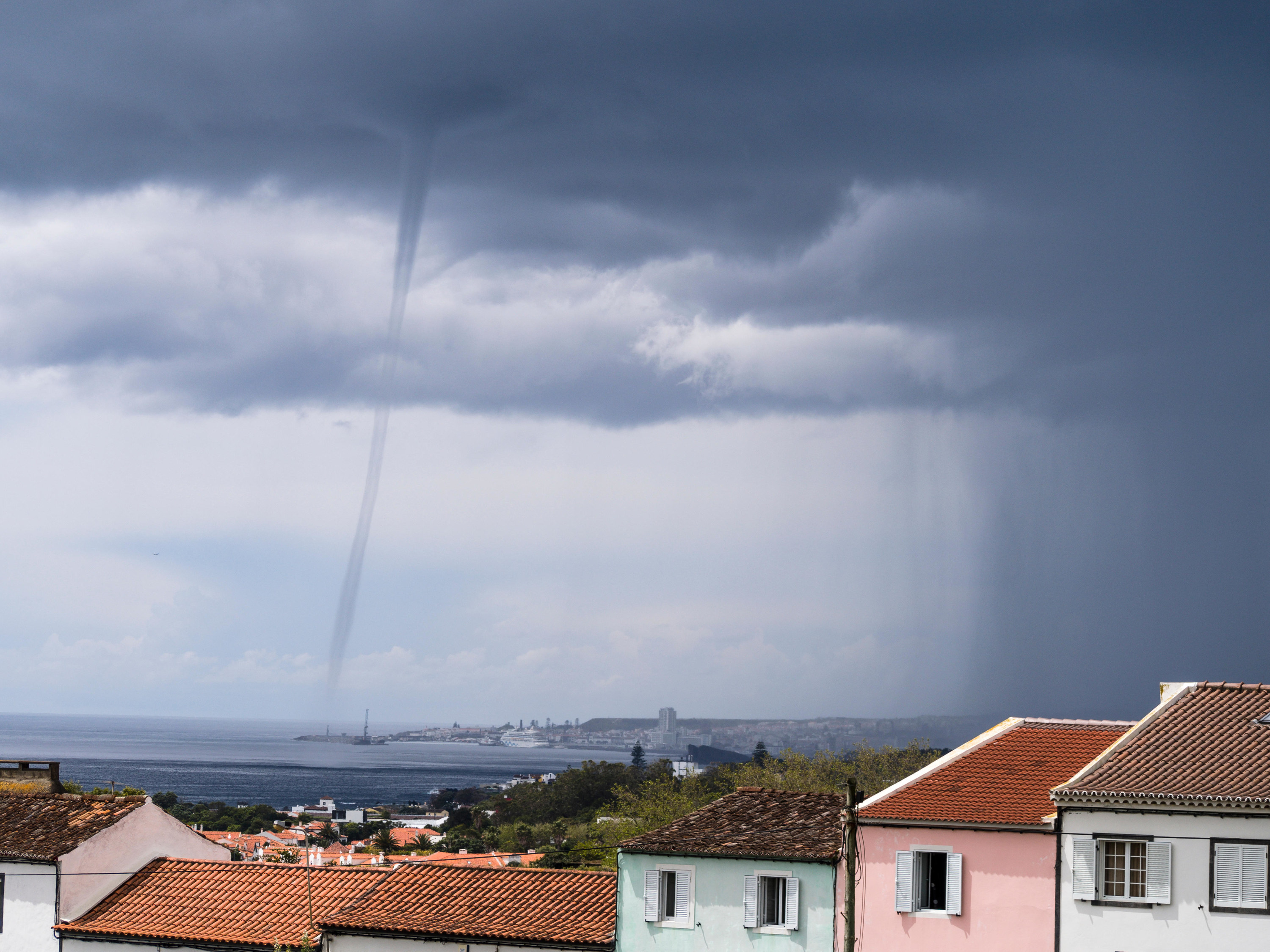 A line descending from a cloud to the water