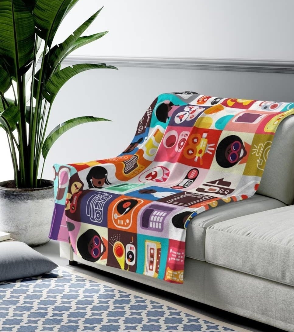 a technology-themed blanket with images of music, cell phones, and more