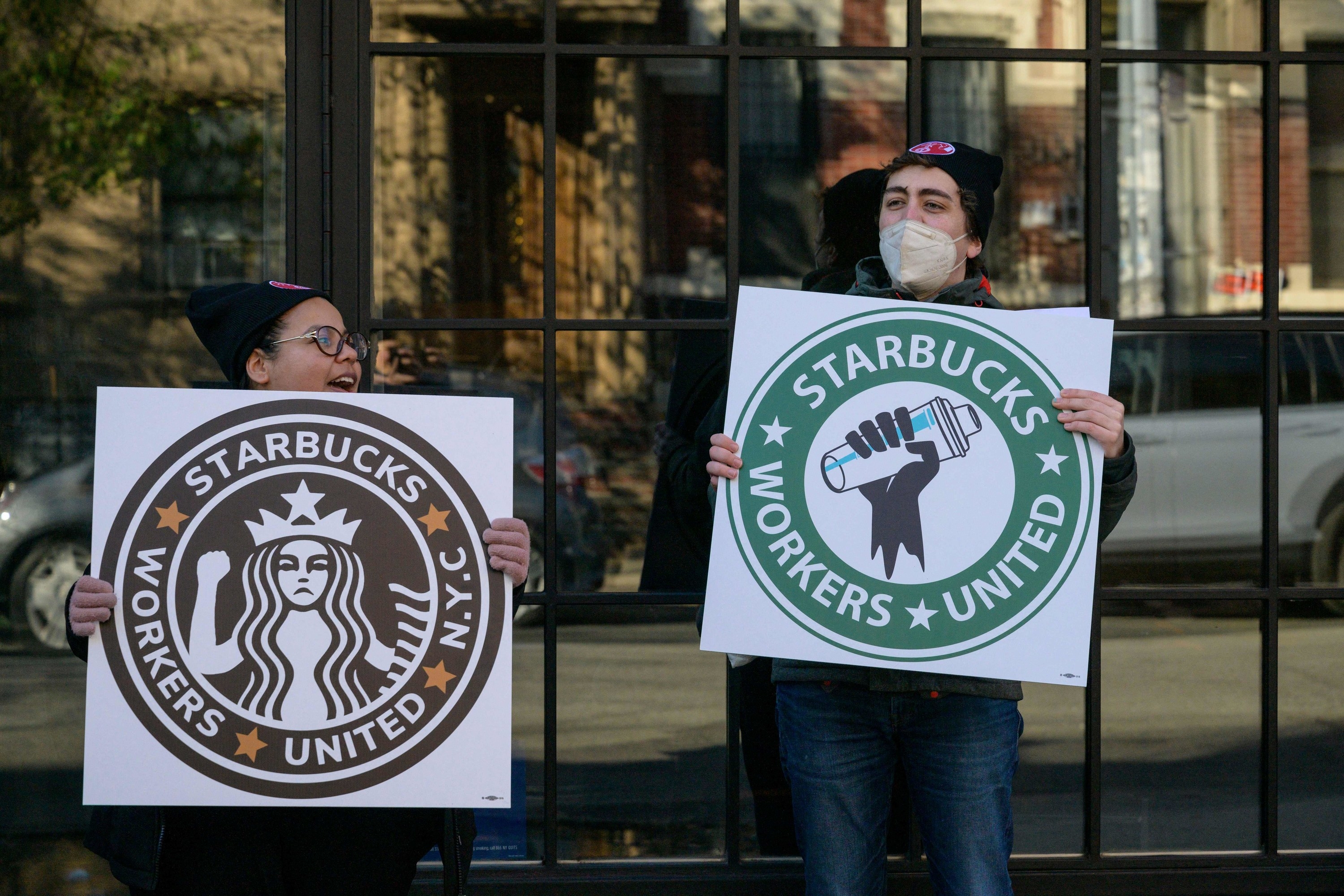 Starbucks workers on strike with signs that say &quot;Starbucks Workers United&quot;