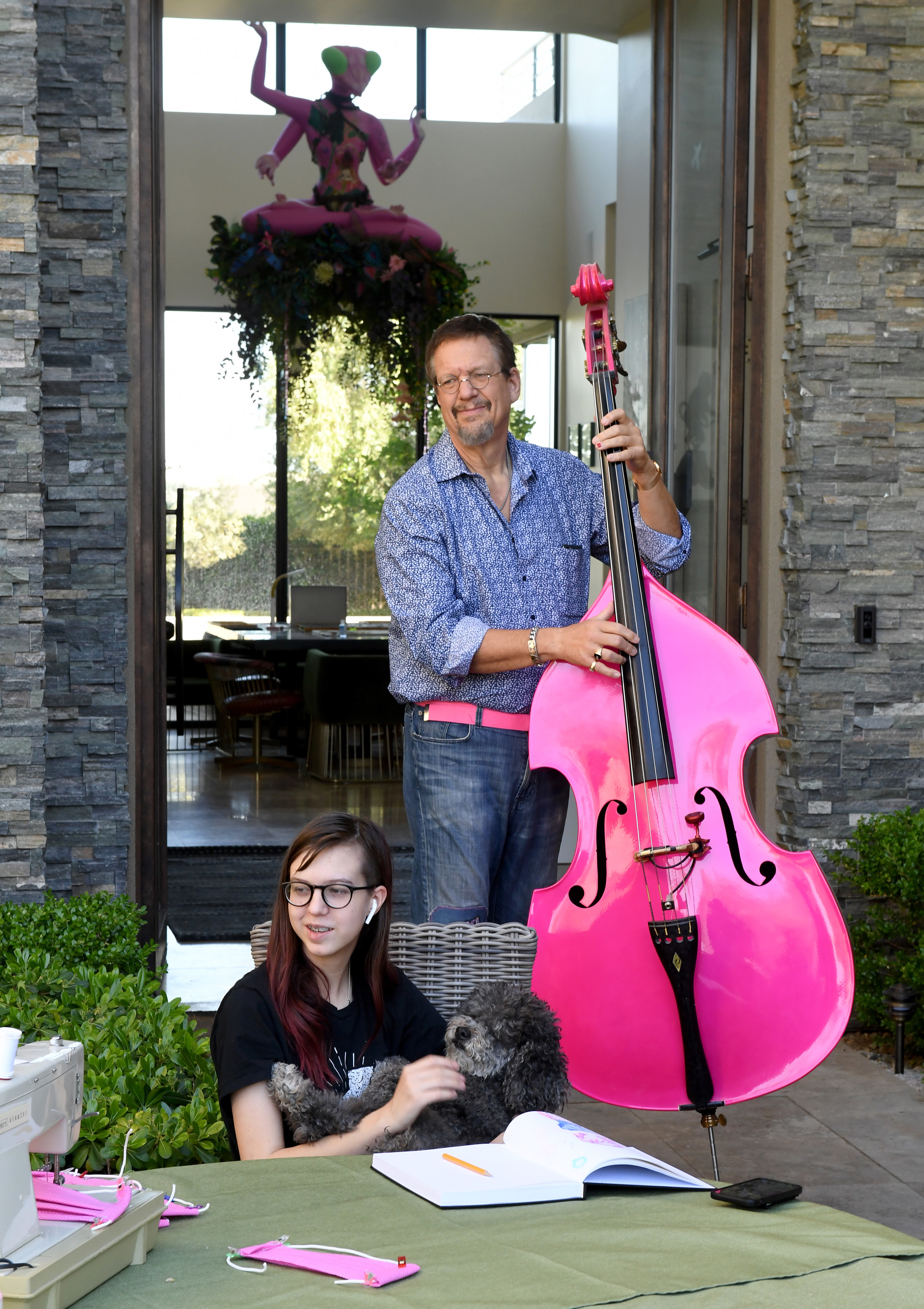 Penn Jillette (R) of the comedy/magic team Penn &amp;amp; Teller, plays a double bass as he and his daughter Moxie CrimeFighter Jillette, holding their dog Betsy