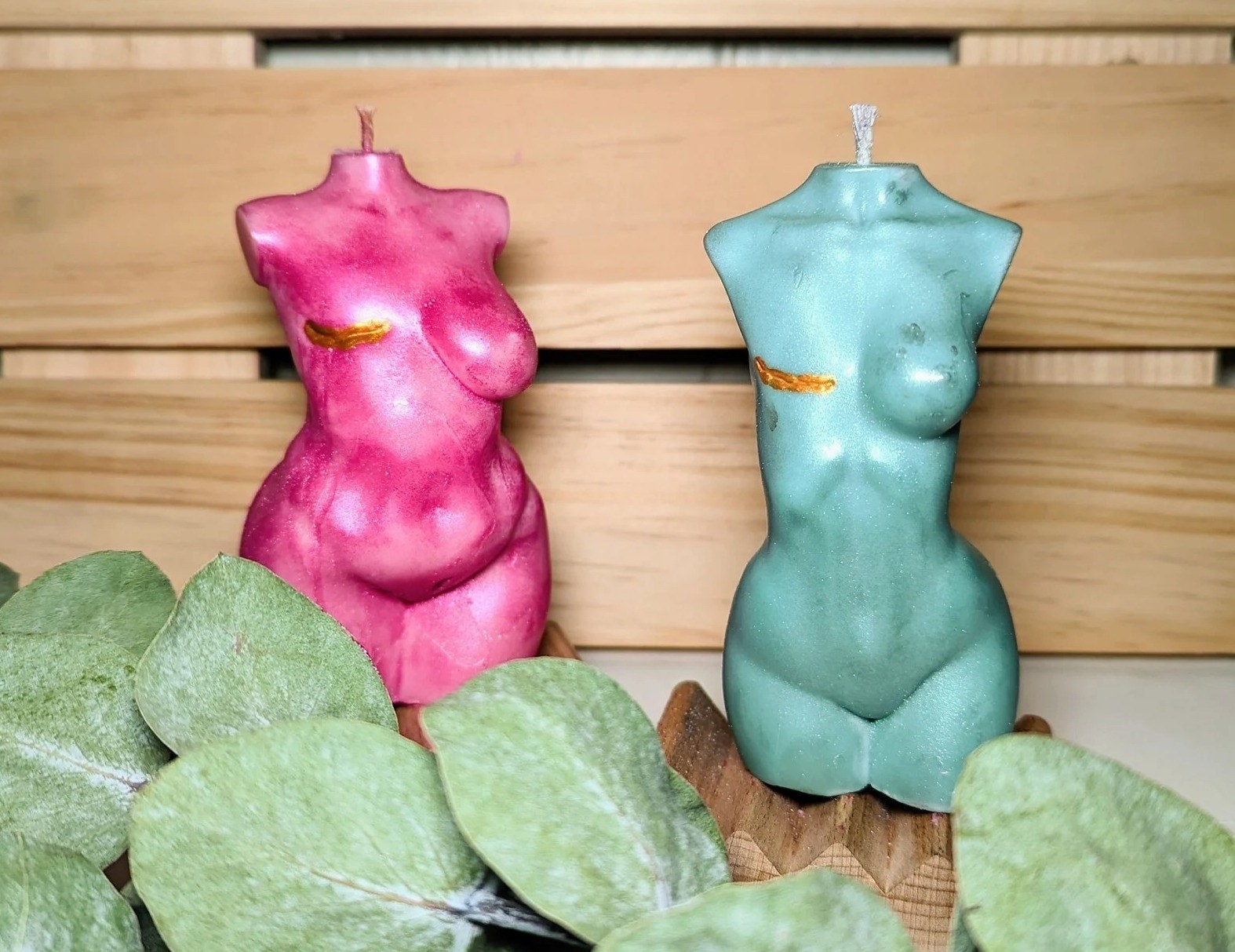 Two candles with human forms are shown with mastectomy scars across the chest