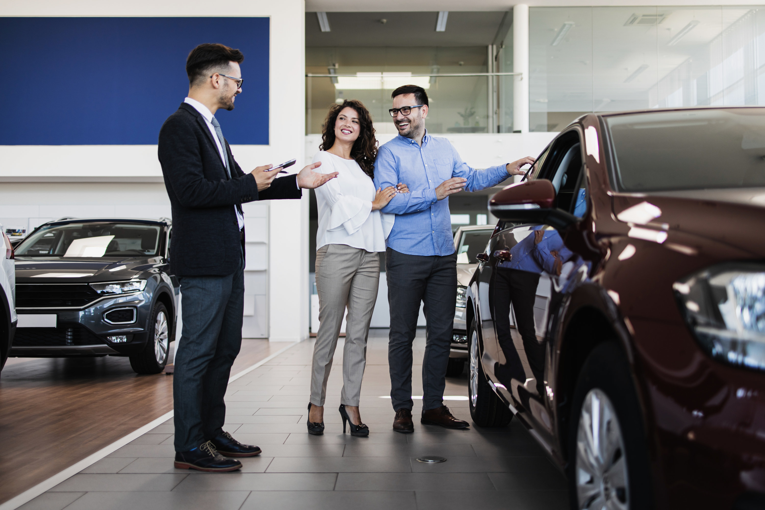 Couple talking to a car salesman at a dealership