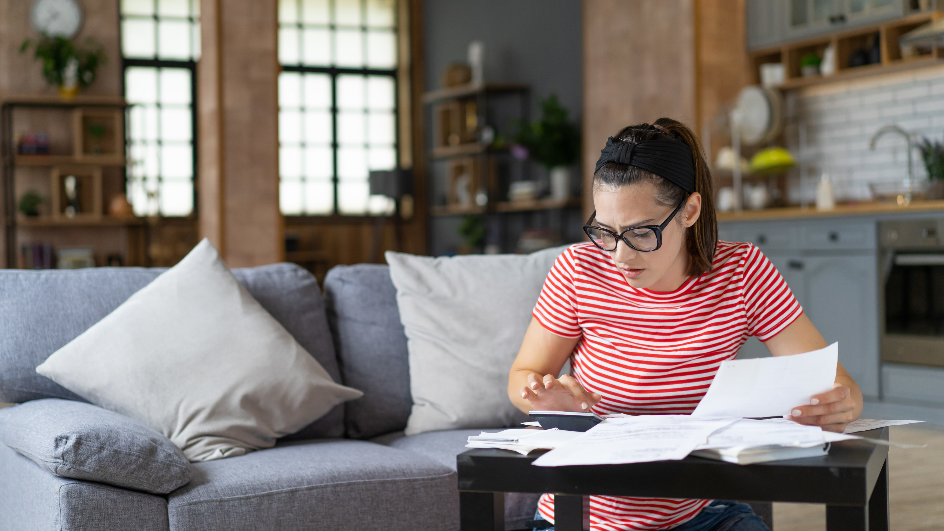 woman sitting with financial paperwork crunching numbers