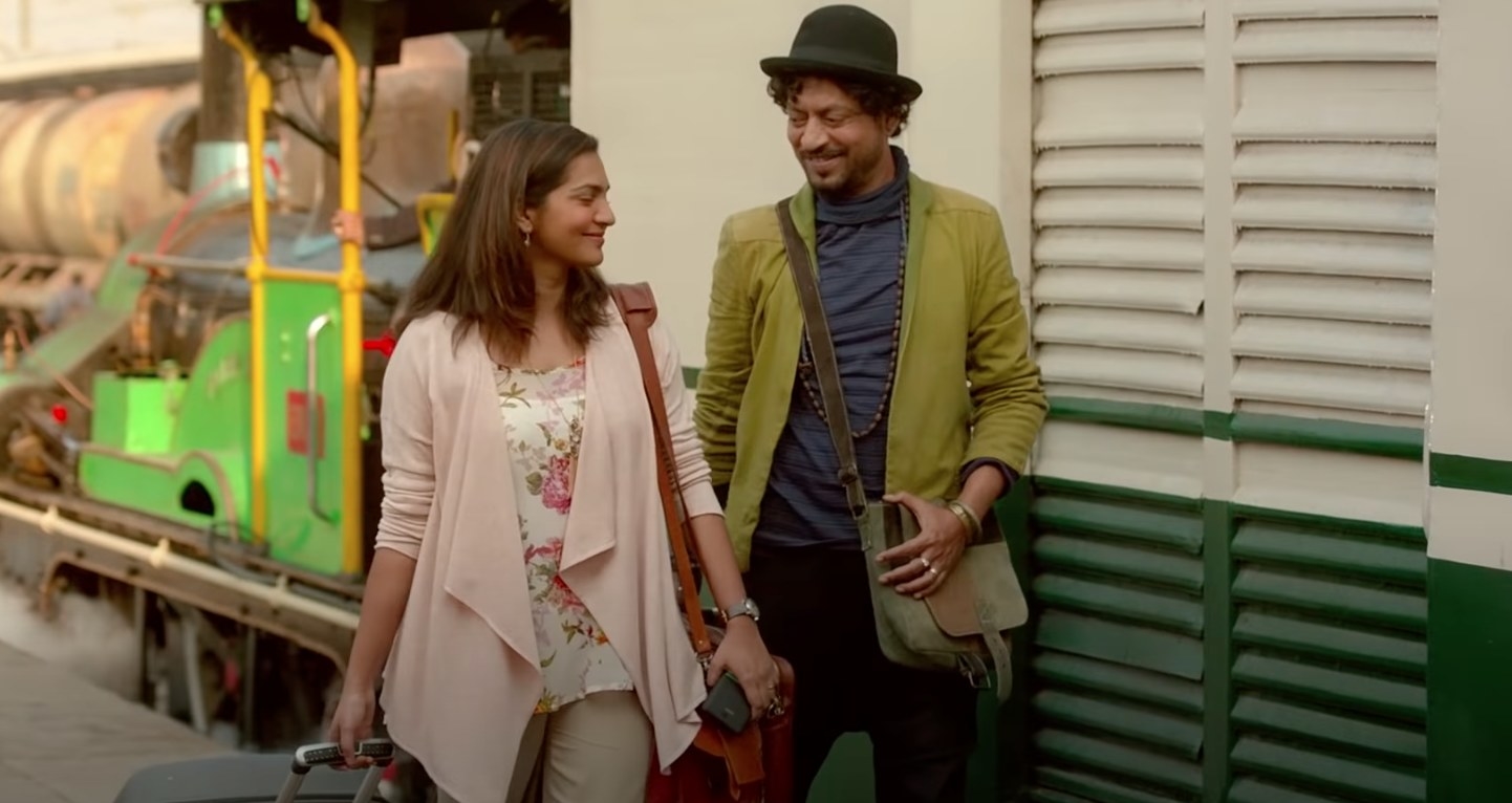 Irrfan and Parvathy smile and walk around at a railway station