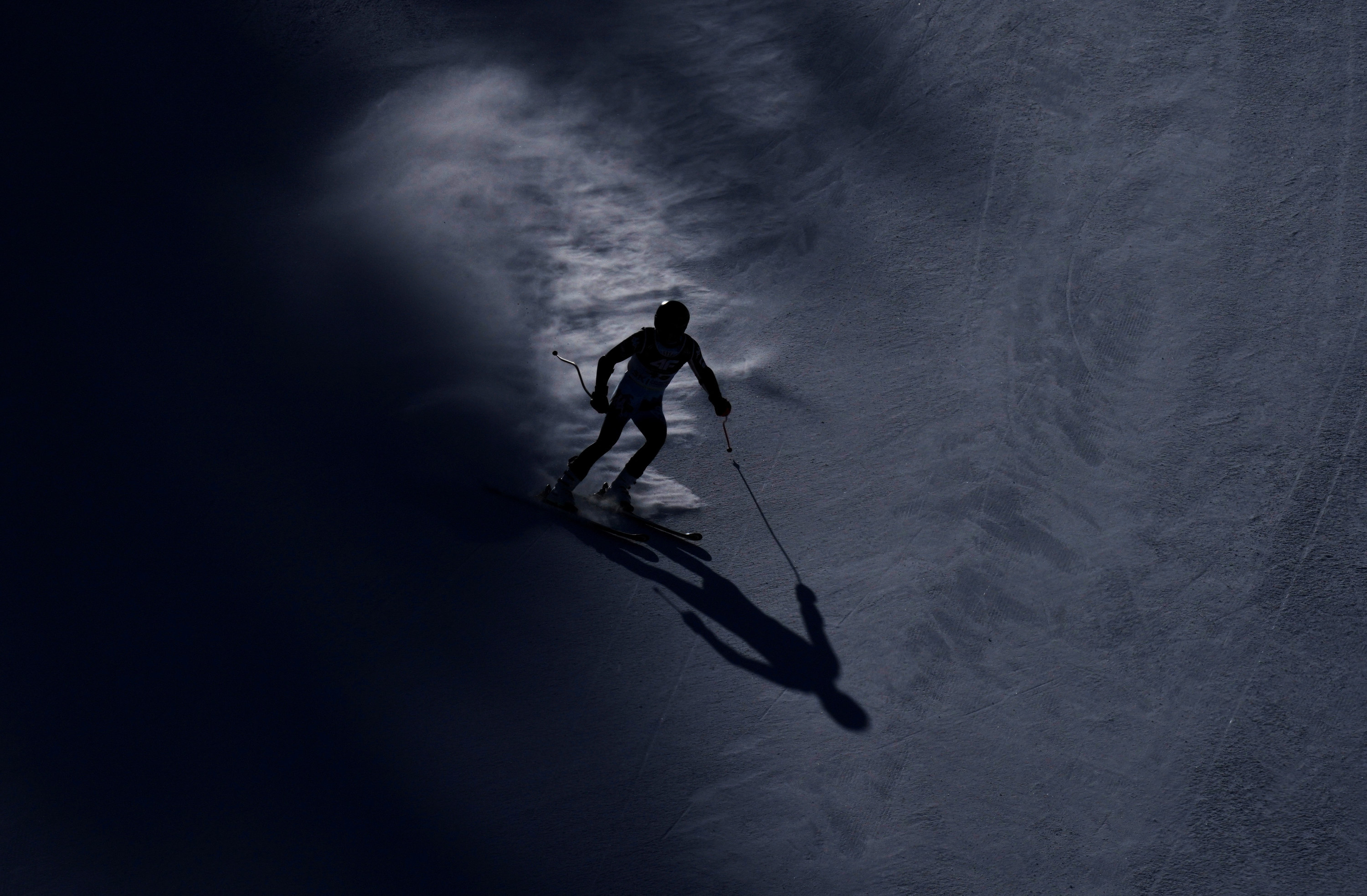 A skier crosses through snow on a dark night
