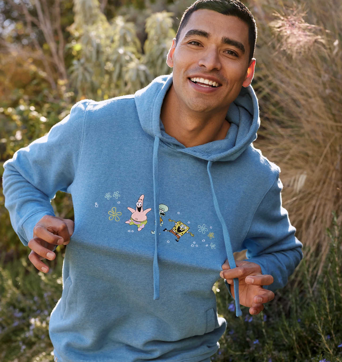 A model wearing a blue hoodie with SpongeBob SquarePant&#x27;s characters