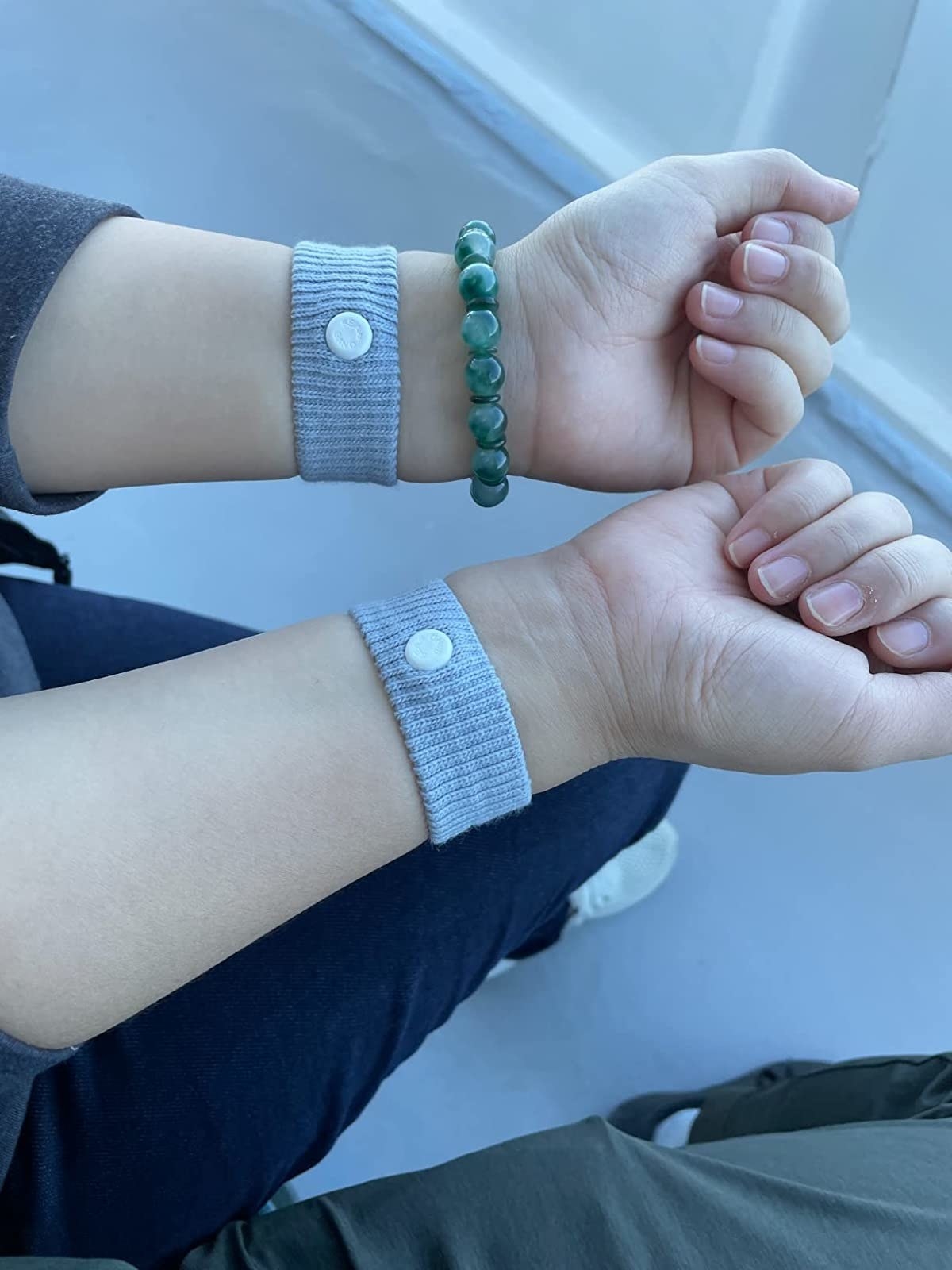 Reviewer&#x27;s photo of them wearing two Sea Bands, one on each wrist
