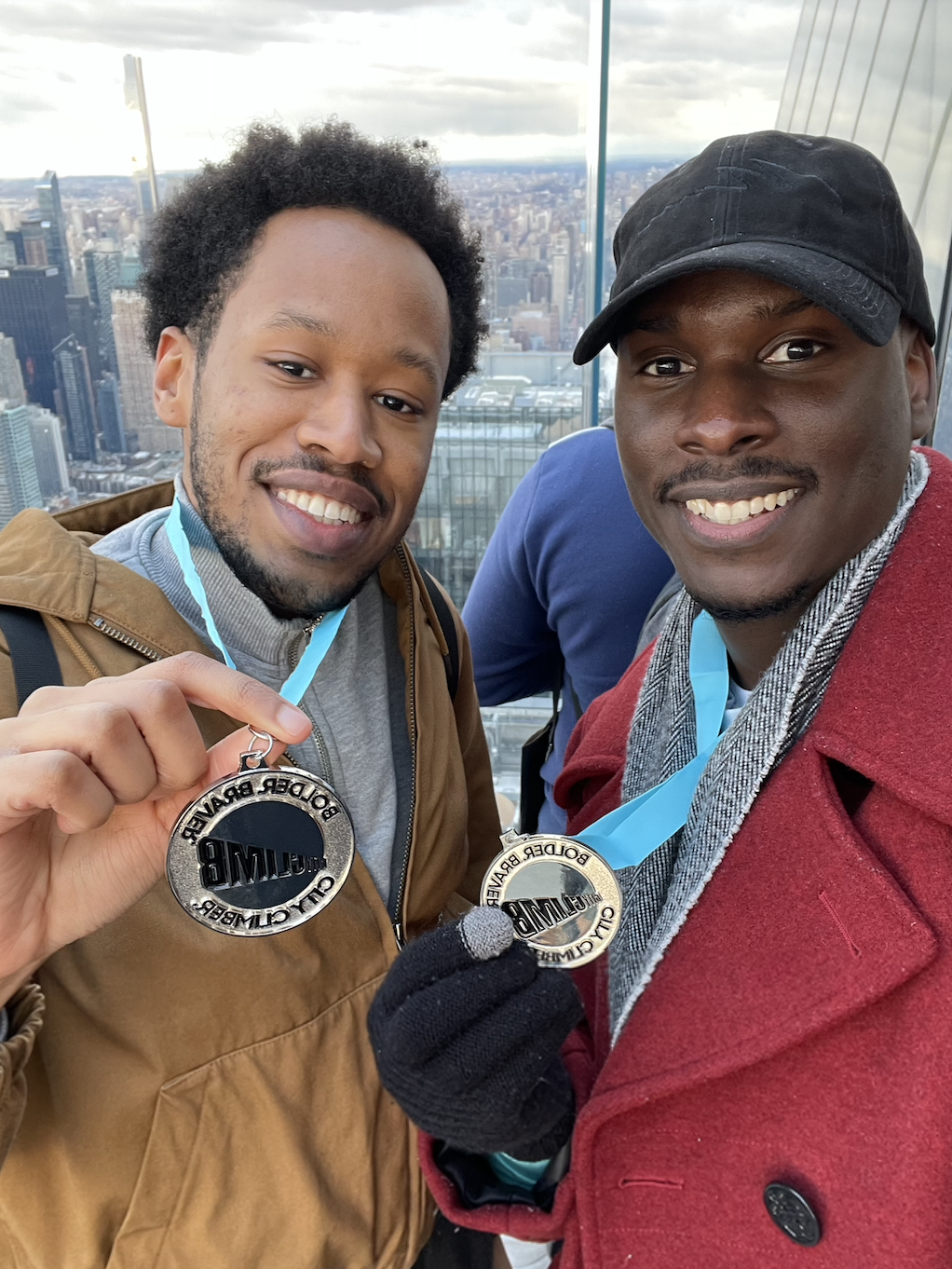 Ajani and Terry holding their medals and smiling