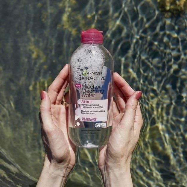 a model holding a bottle of the micellar water