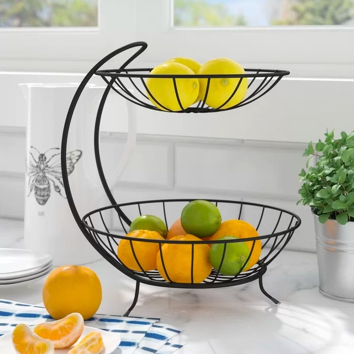 the black basket with fruit inside