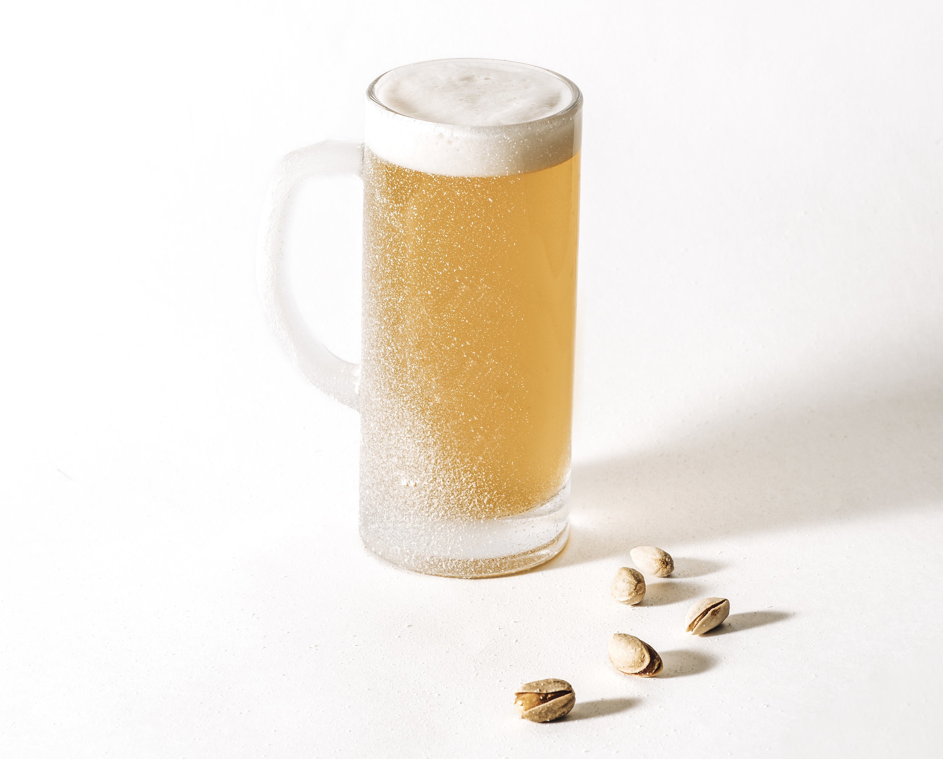 mug of beer with loose peanuts nearby