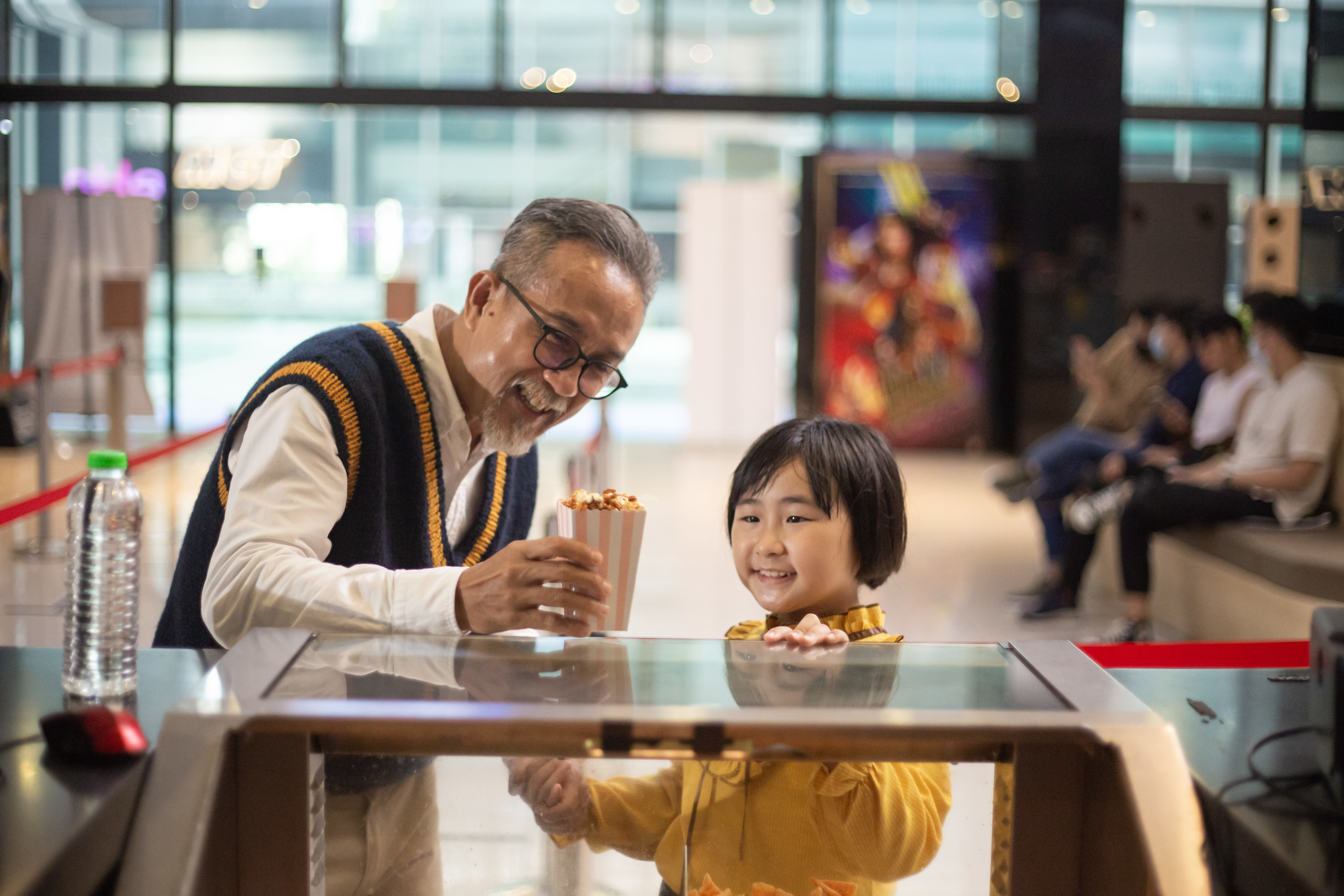 Father and child getting snacks at a movie theater