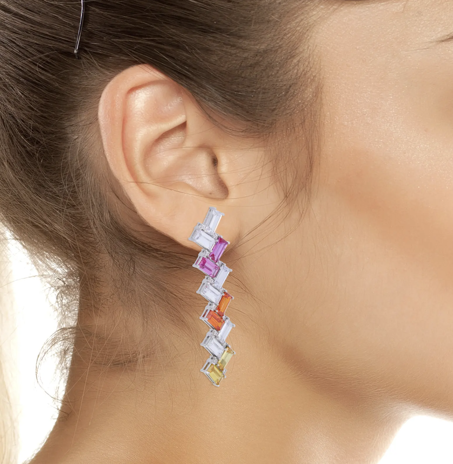 A person wearing one of the dangly earrings