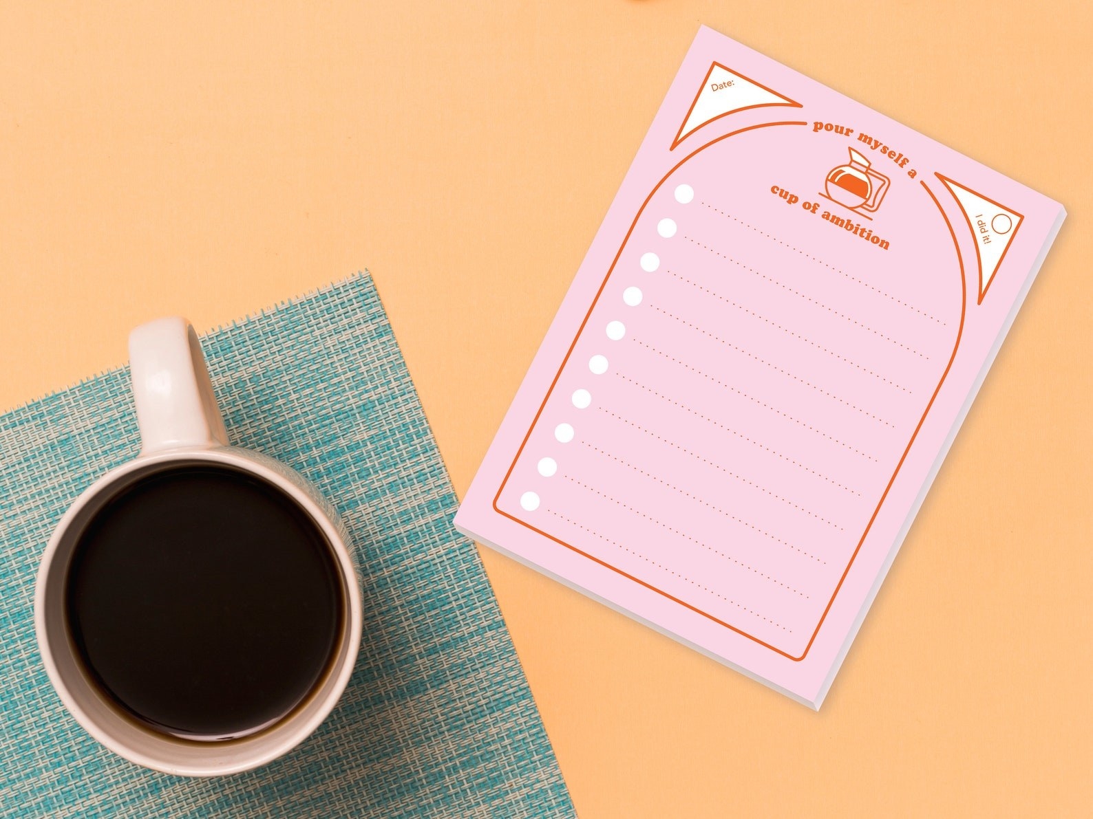 The pink notepad with a coffee pot icon and &quot;pour myself a cup of ambitiion&quot; with date box and room for 10 to-do tasks