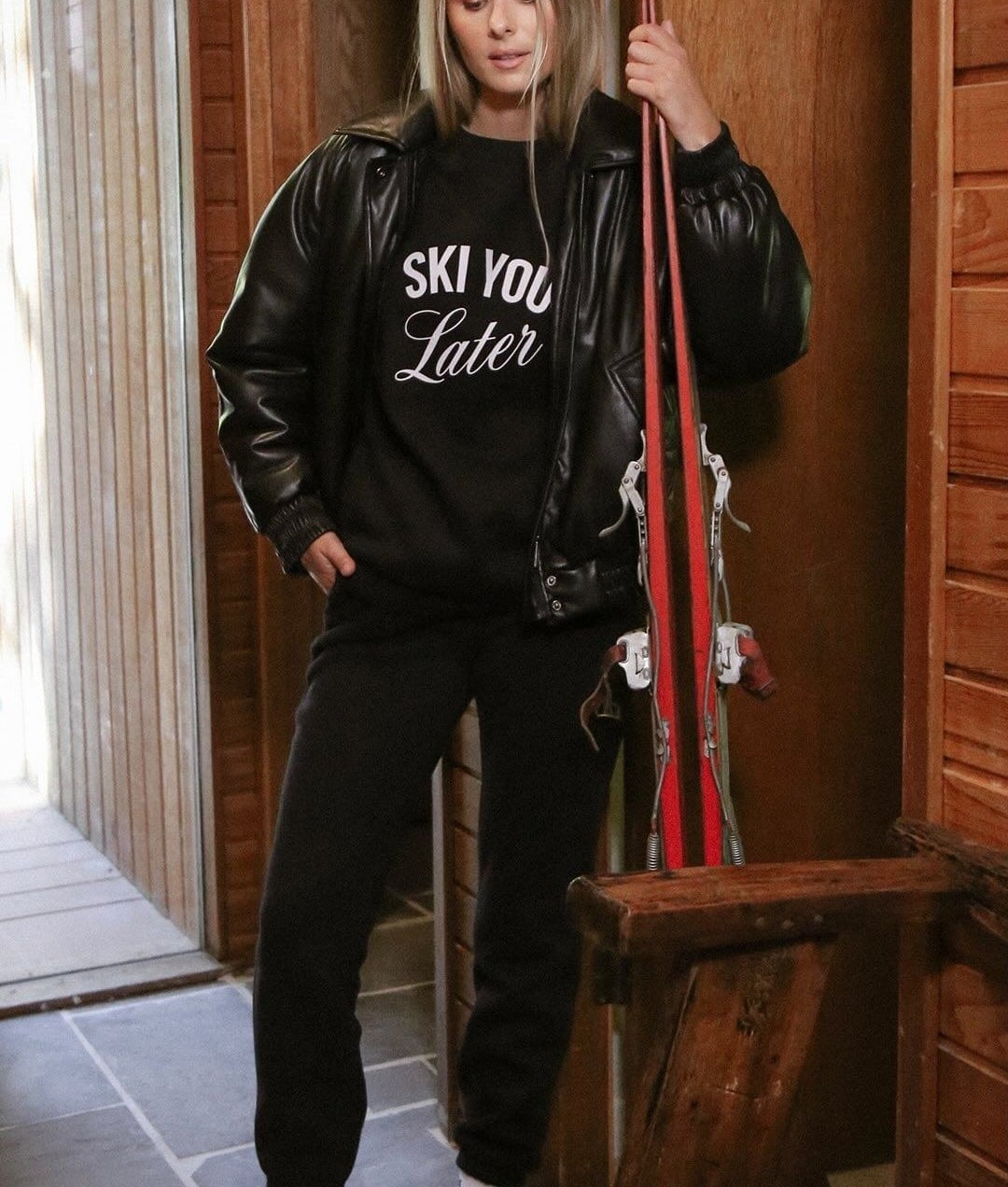 A person wearing the crewneck and holding skis