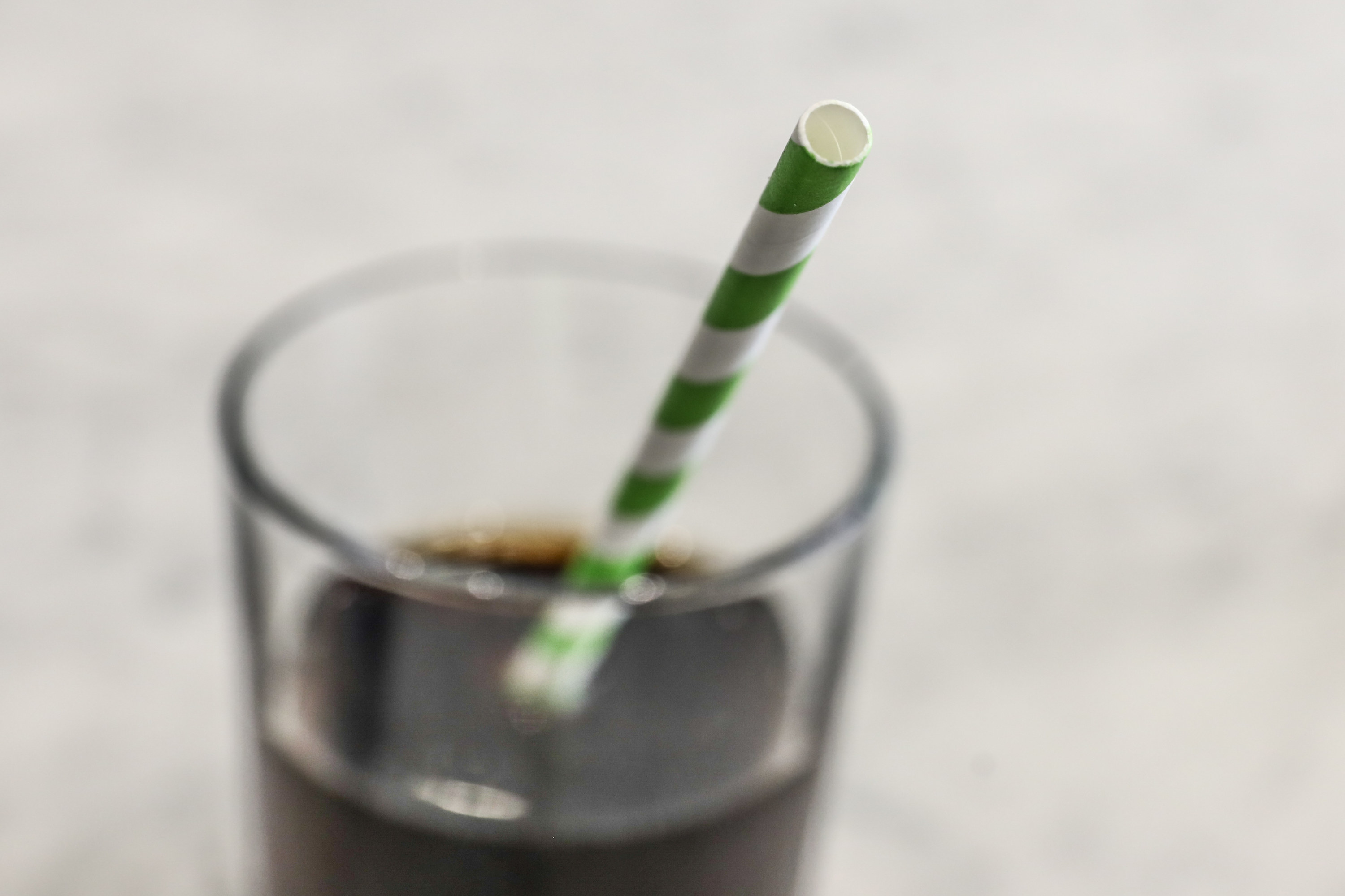 Glass with a green-and-white striped straw