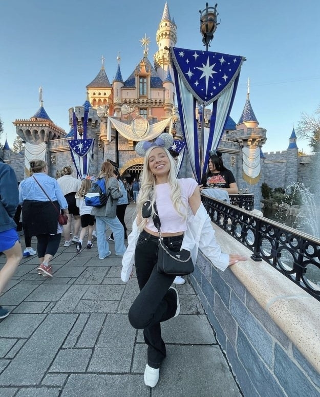 A girl posing in front of the Disneyland character