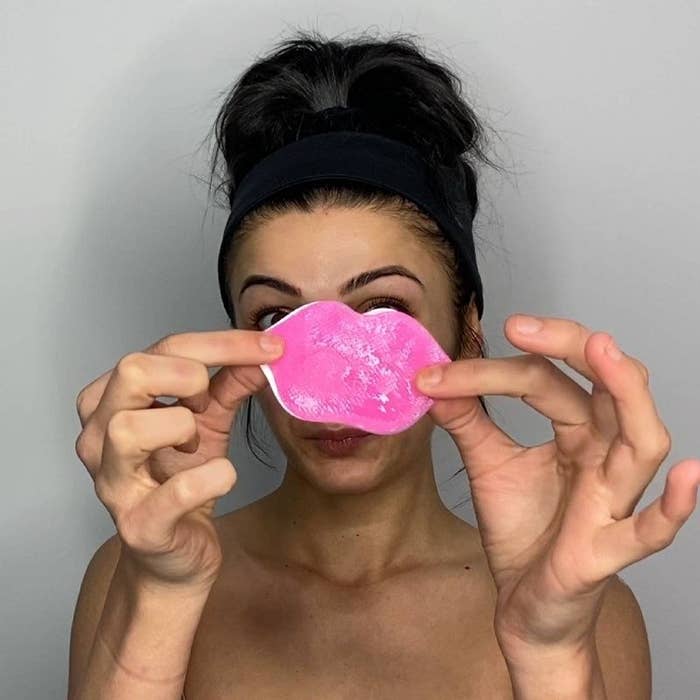 A person holding a pink lip mask