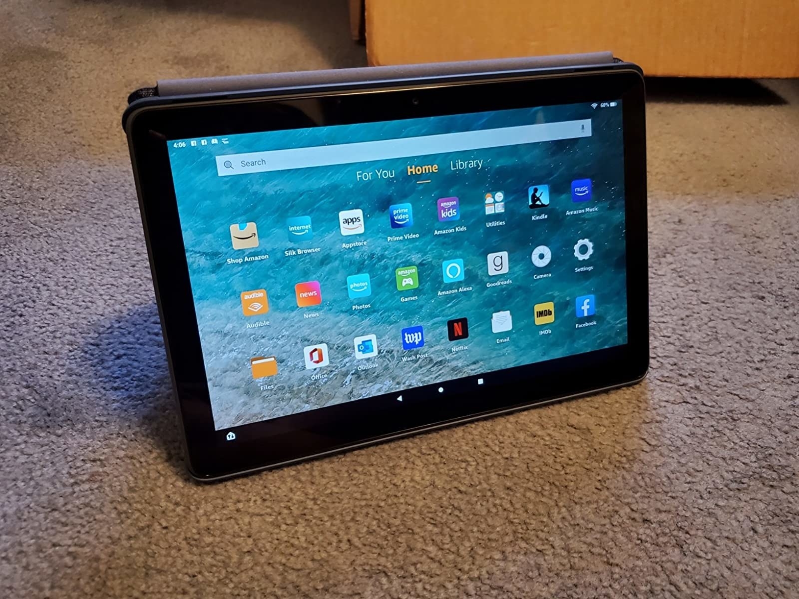 Reviewer&#x27;s tablet propped up on carpet with homescreen on display