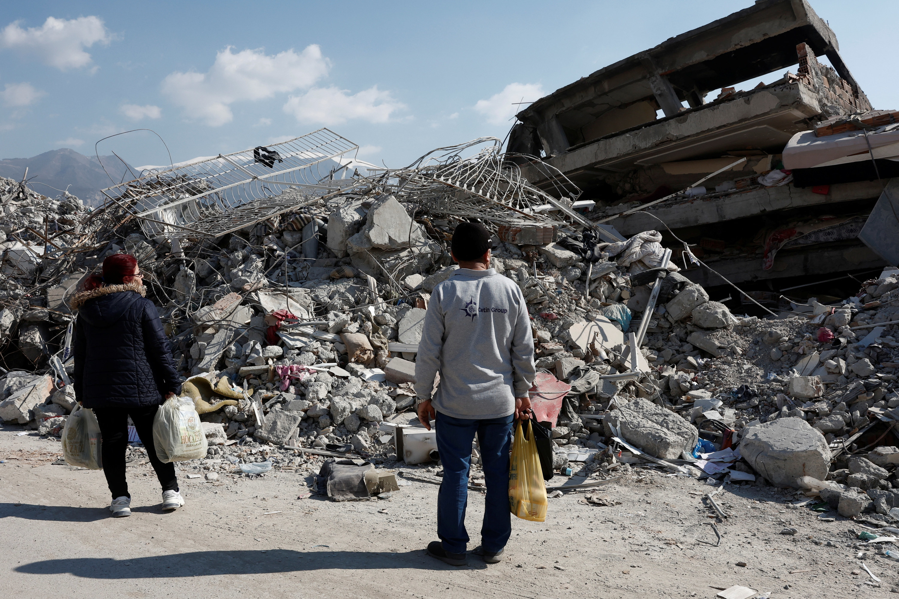 Two people looking at rubble