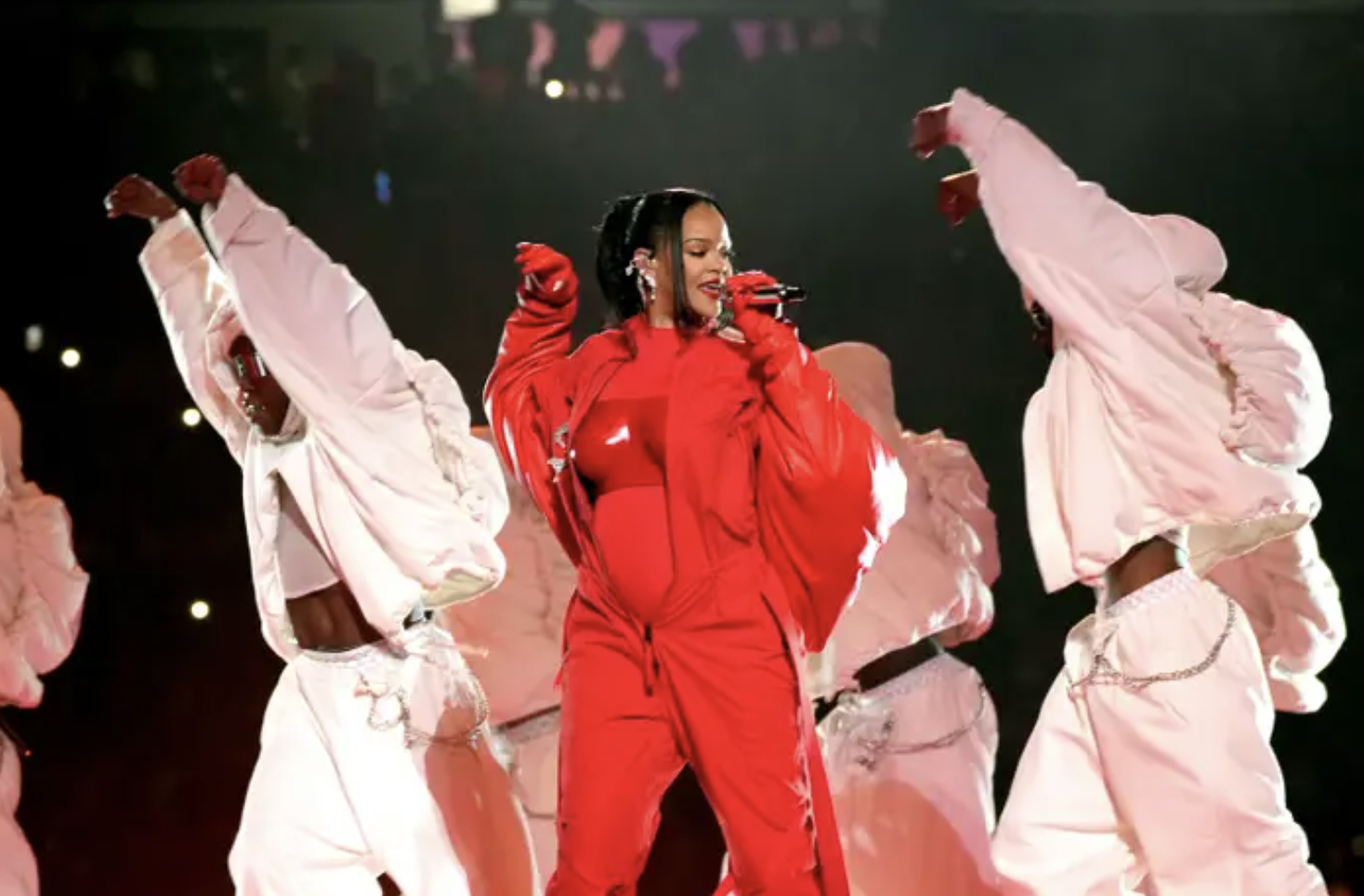 rihanna glowing onstage at the super bowl surrounded by back up dancers in white