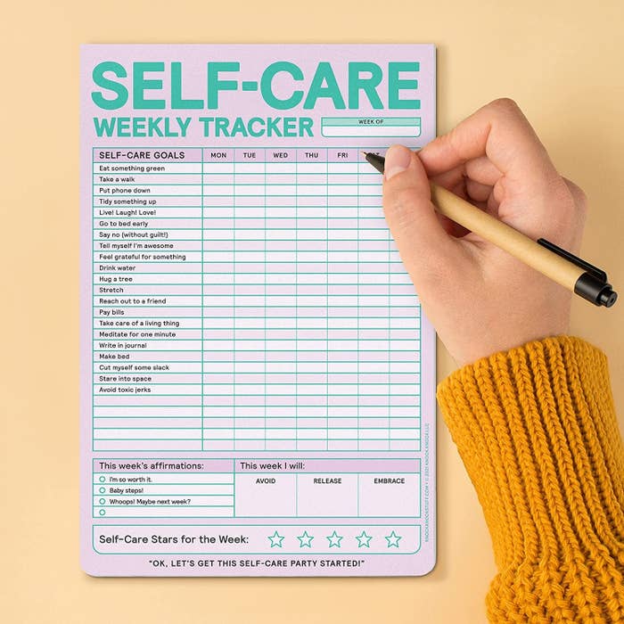 a person drawing on the self-care tracking pad