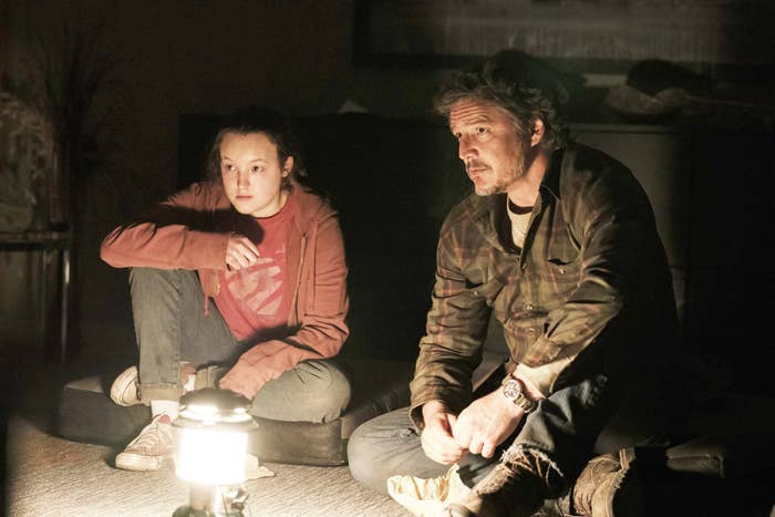 Ellie and Joel sitting together with a lamp beside them
