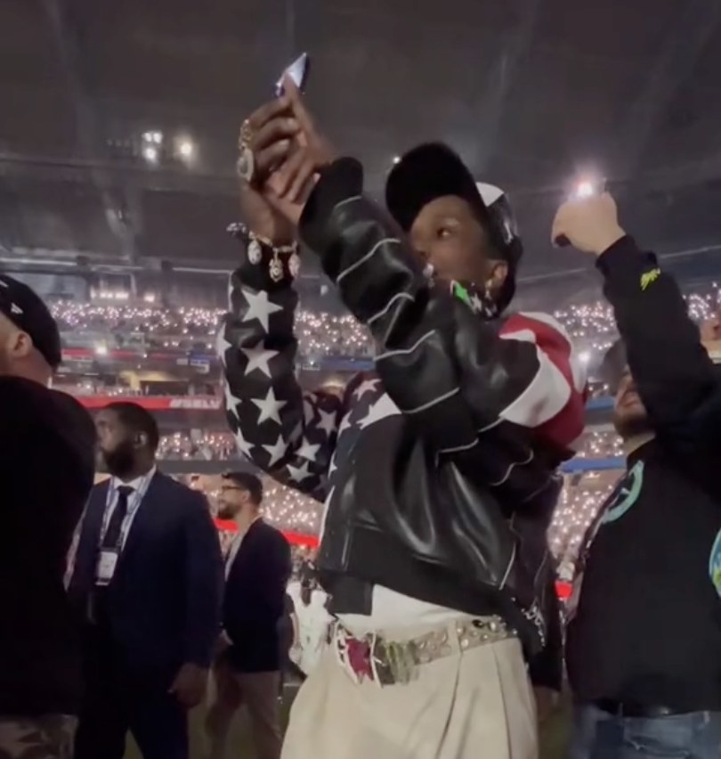 ASAP holds his phone in the air