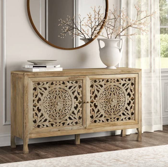 A light wooden cabinet table with a mandala design