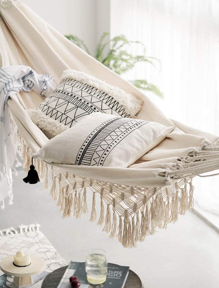 a hammock hanging indoors with pillows on it